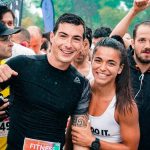 Group of runners smiling in the rain during a marathon race event.